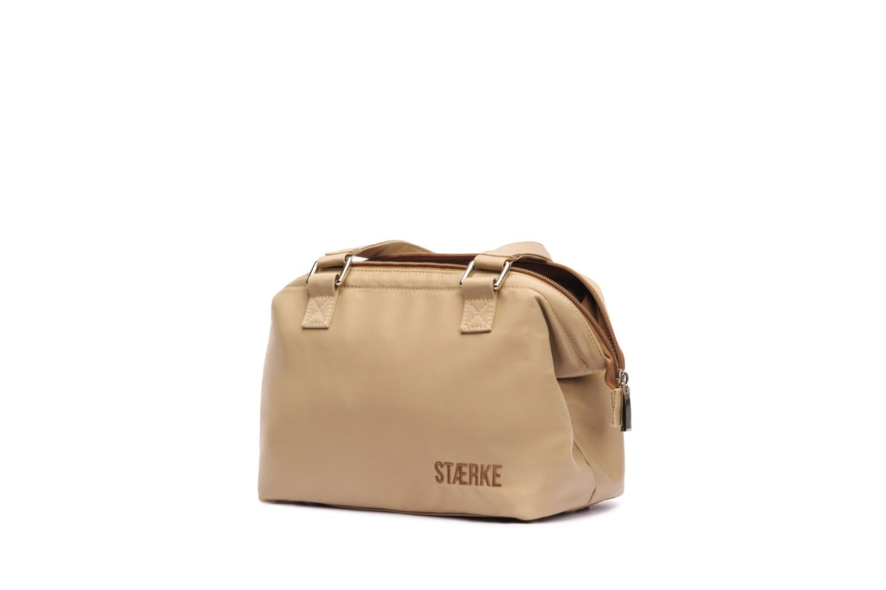 STÆRKE mini gym bag angled view, compact sustainable gym bag in beige recycled nylon