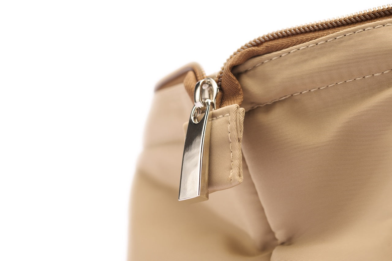 STÆRKE mini gym bag close-up of silver zipper and beige recycled nylon fabric