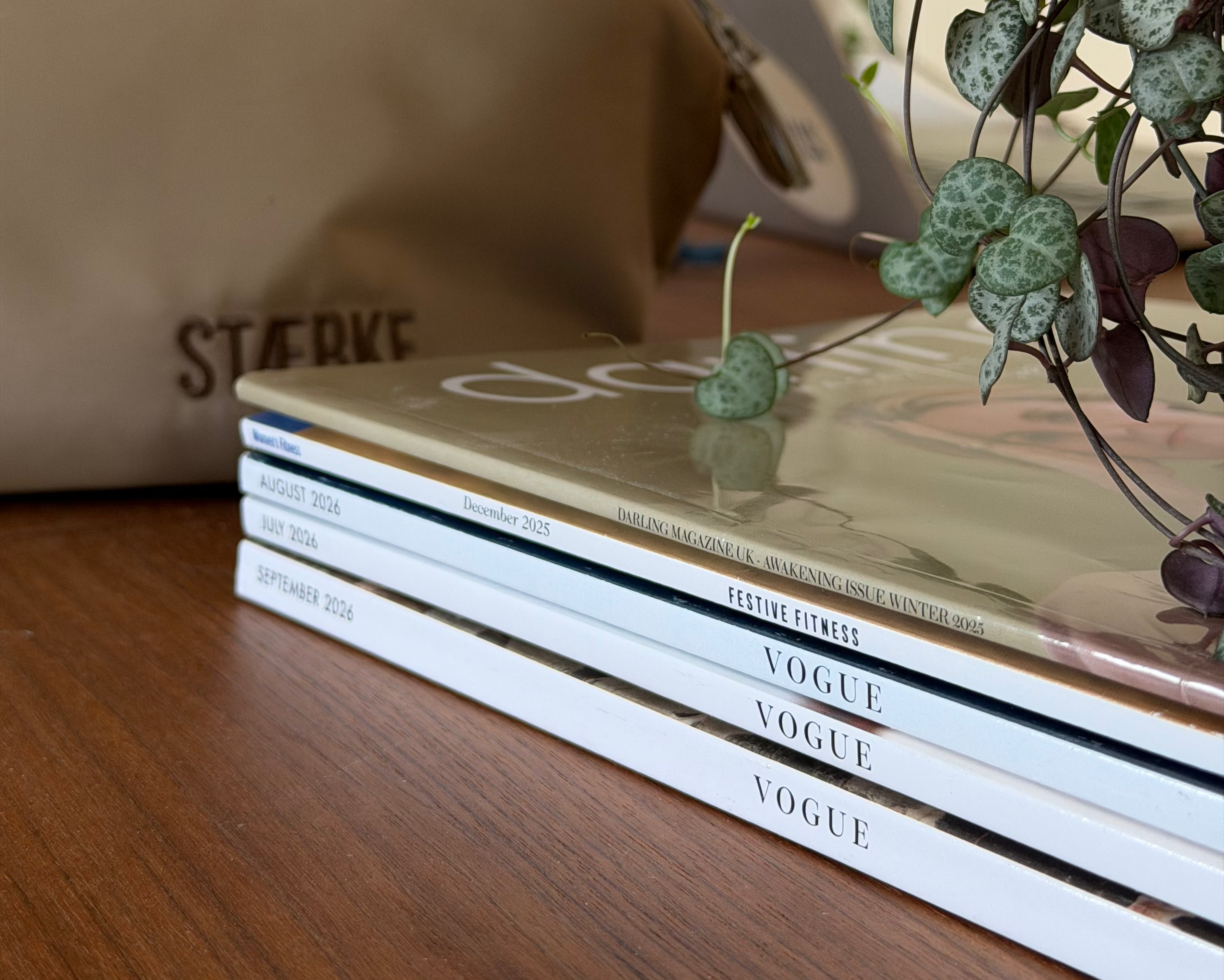 A beige STÆRKE Mini Gym Bag with Magazines (Vogue, Darling Magazine, Women's Fitness). 